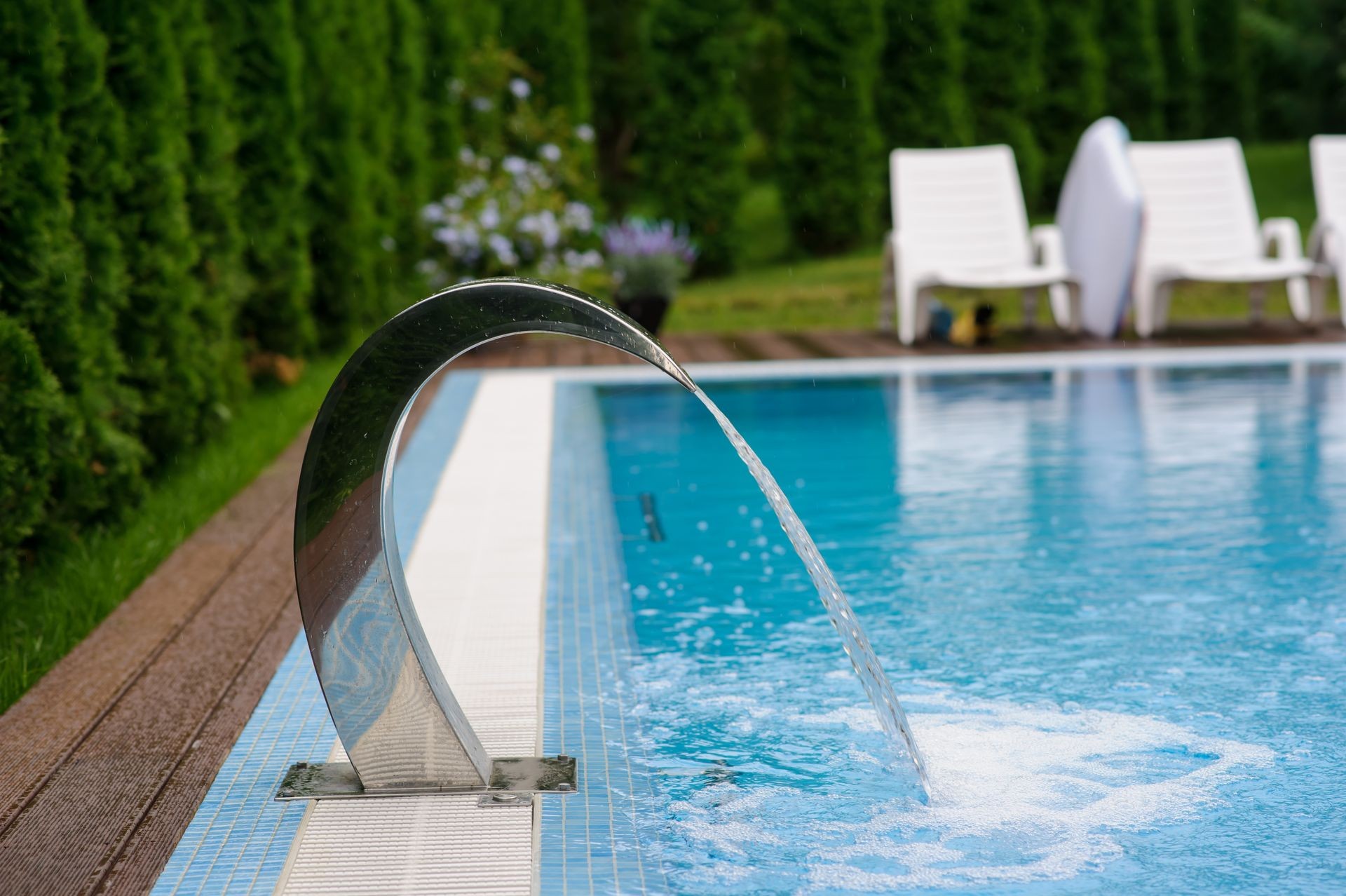 View of a empty swimming pool with blue water outside. Light day and clean background outside in the garden.